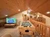 Upstairs loft area with tv, seating, and foosball table.