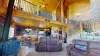 Upon entry is a large living room with seats and views of the loft upstairs.
