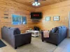 Picture a warm, open-concept living room with a cabin vibe—wood tones, soft textures, and a layout that encourages conversation and connection.