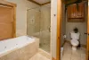 Main floor master bathroom with tub, standing shower, toilet, and sink vanity.