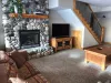 Basement living room with tv and fireplace.