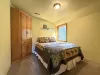 Bedroom complete with a bedside table, lamp, closet, and a window.