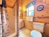 Upstairs bathroom with standing shower, toilet, and sink vanity.