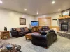 Basement living room with fireplace, seating, and television.