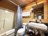 In the ensuite bathroom there is a large vanity, toilet, and a shower tub combo.