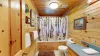 Main level bathroom with shower/tub, toilet, and sink.
