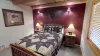 On either side of the bed are matching wooden nightstands, each topped with a simple lamp.