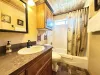 Downstairs bathroom with a shower tub combo, toilet, and sink vanity.