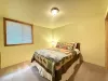 Bedroom located in the basement with a queen size bed and closet.