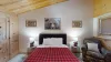 The bedroom has a queen bed, additional seating, and a large window to enjoy the beautiful landscape.