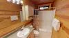 Upstairs shared bathroom with shower tub combo, toilet, and double sink vanity.