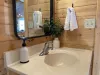 Main floor bathroom with a shower tub combo, toilet, and sink vanity.