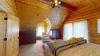 This upstairs bedroom offers a cozy escape within the cabin, providing both comfort and a deep connection to the natural beauty of the surrounding area.