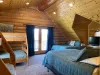 The ample number of beds—three queens, two twins, and two fulls—ensures that there’s plenty of space for everyone, whether for a family, a group of friends, or extended guests. Despite the large number of beds, the room remains inviting and cozy.
