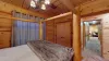 The first bedroom in the basement has a warm, inviting feel, with the walls adorned in rich, natural wood paneling, which gives it that quintessential cabin vibe.