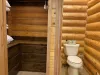 The closet is built into the wall and has shelves for extra towels and linens, as well as hanging space for coats and clothing. Its wooden shelves, hanging rods, and drawers are simple yet practical.