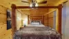 At the center of the room is a queen-sized bed with bedside table located on both sides.