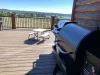 The outdoor deck serves as an inviting and functional extension of the cabin’s living space, offering a perfect setting for outdoor cooking, dining, and relaxation.