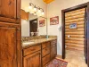 This bathroom is equipped with a walk in shower, toilet, and double sink vanity.