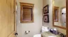 Main level shared bathroom with walk in shower, toilet, and sink vanity.
