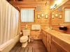 The bathroom is spacious and serene, blending the rustic elegance of the cabin with a touch of spa-like comfort.