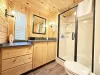 The bathroom is spacious and serene, blending the rustic elegance of the cabin with a touch of spa-like comfort.