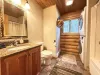 Main level bathroom with shower tub combo, toilet, and sink vantiy.