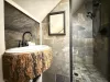 The ensuite bathroom is equipped with sink, standing shower, and toilet.