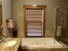 Bathroom is equipped with a soaking tub, standing shower, toilet, and double sink vanity.