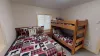 Bedroom #4 located in the basement with a Queen size bed and bunk bed.