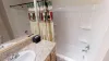 Basement shared bathroom with shower tub combo, toilet, and sink vanity.