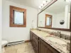 Bathroom #3 located upstairs equipped with shower/tub, toilet, and double sink.