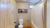 Full size bathroom with shower tub combo, toilet, and sink vanity.