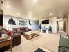 Upon entrance of the cabin you view the downstairs living room. Equipped with a smart tv and seating to relax during your stay.
