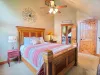 The second upstairs bedroom offers a warm, inviting atmosphere with a comfortable queen bed and high-quality wooden furnishings. There is also a closet to store your belongings during your stay.