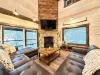 View of the living room smart tv and propane fireplace along with the beautiful views out the windows.
