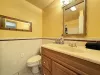 Full bathroom in the basement with shower tub combo, sink, toilet, and vanity storage. Towels are provided.