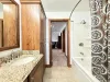 Bathroom #3 located upstairs equipped with shower/tub, toilet, and double sink.