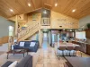 Access to the third level is up the stairs. The open kitchen blends seamlessly into the cabin's cozy living area, creating a welcoming space perfect for gathering and unwinding.