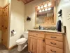 Main level shared bathroom equipped with shower tub combo, toilet, and sink vanity.