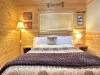 At the center of the room is a queen-sized bed with a chunky wood frame bringing that raw, rustic charm.