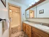 Shared basement bathroom with shower/tub, toilet, and sink vanity.