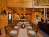 Host unforgettable group dinners at the grand wooden dining table, beautifully set under a warm lantern centerpiece and connecting seamlessly to the living space.