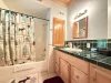 Full bathroom with shower tub combo, sink, toilet, and vanity storage. Towels are provided.