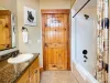 A clean and fully equipped upstairs bathroom featuring a convenient shower-and-tub combo and a toilet, perfect for a relaxing soak.
