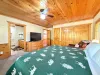 Master bedroom with a King size bed, armchair, and television.