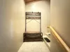 coat and shoe bench on the landing at the top of the stairs
