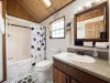 Full bathroom with shower tub combo, toilet, and sink vanity.