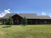 Lots of open grass surrounding the cabin.