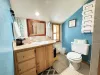 Upstairs bathroom with a full sink vanity, toilet, and standing shower.